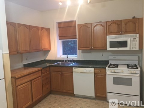 A kitchen with wooden cabinets and white appliances.