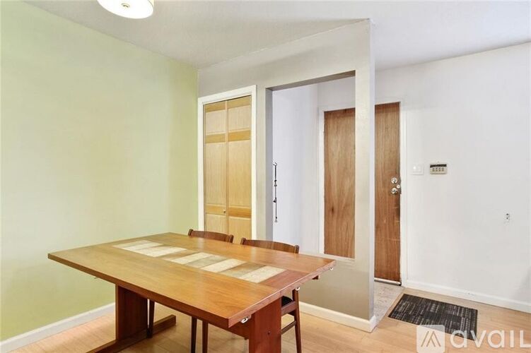 A dining room with a wooden table and chairs.