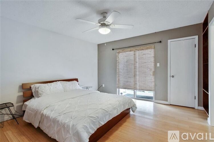 A bedroom with a large bed and a ceiling fan.