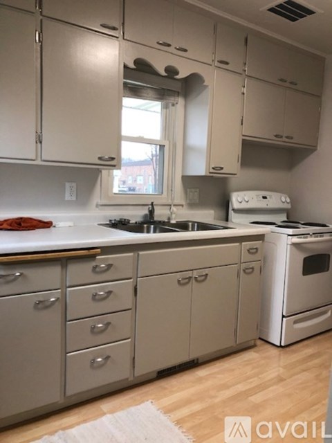 A kitchen with white cabinets and a white oven.