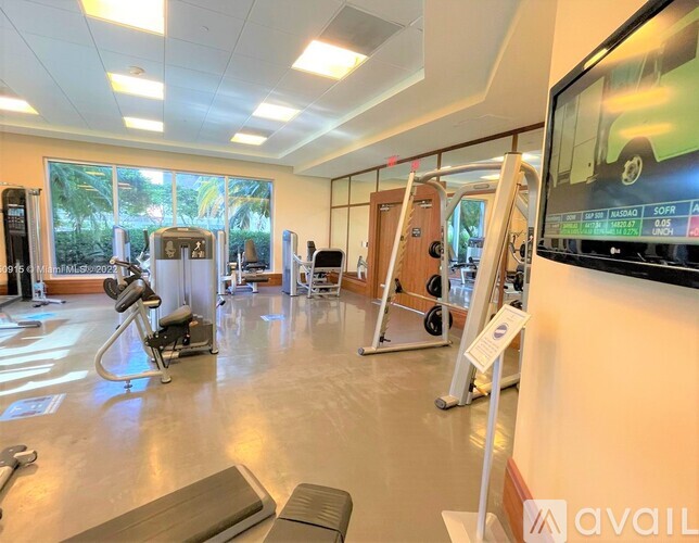 A gym with a variety of equipment including treadmills, weights, and exercise machines.