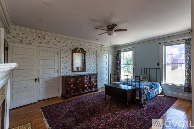 A bedroom with a bed, dresser, and mirror.