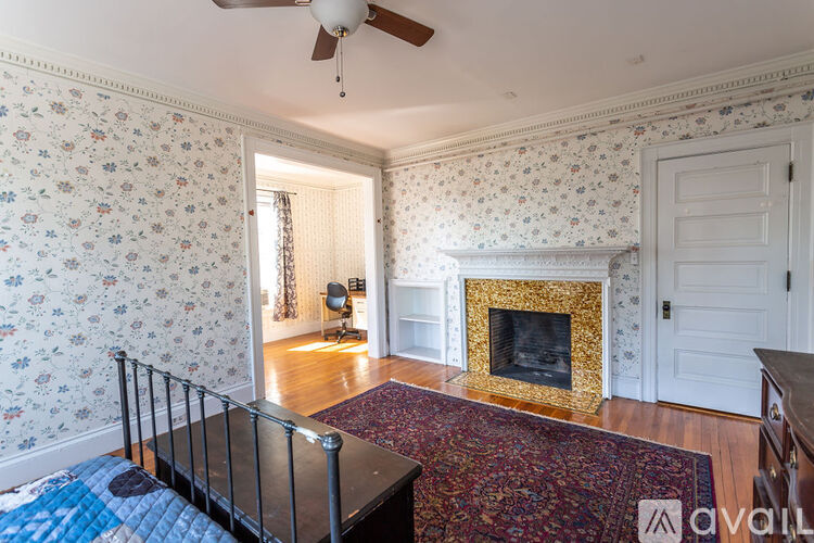 A room with a fireplace and a fan on the ceiling.