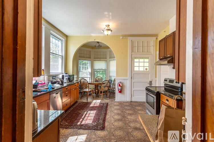 A kitchen with a rug on the floor and a fire extinguisher on the wall.