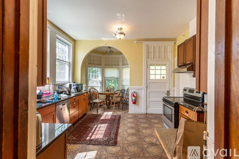 A kitchen with a rug on the floor and a fire extinguisher on the wall.