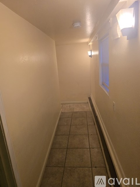 A long hallway with tiled floors and white walls.