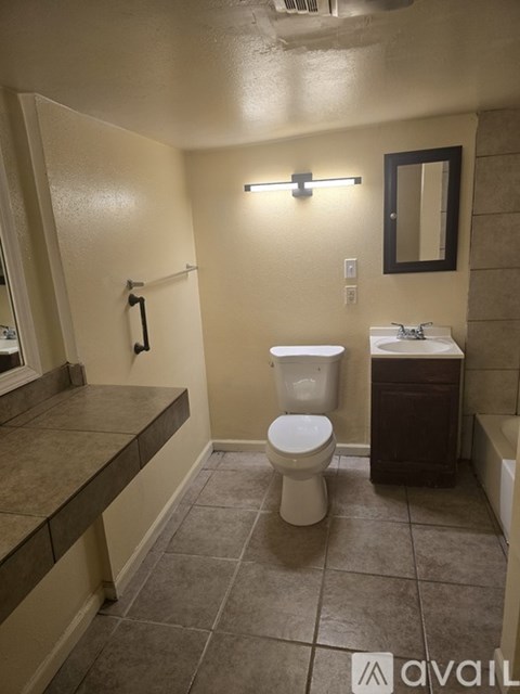 A bathroom with a toilet, sink, and mirror.