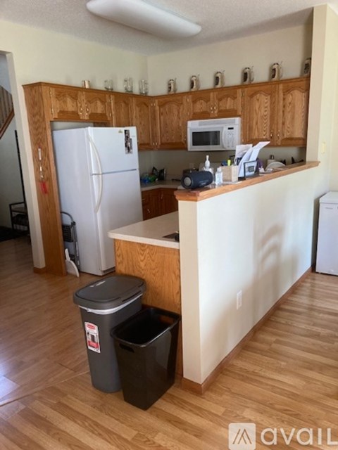 A kitchen with a white fridge and wooden cabinets.