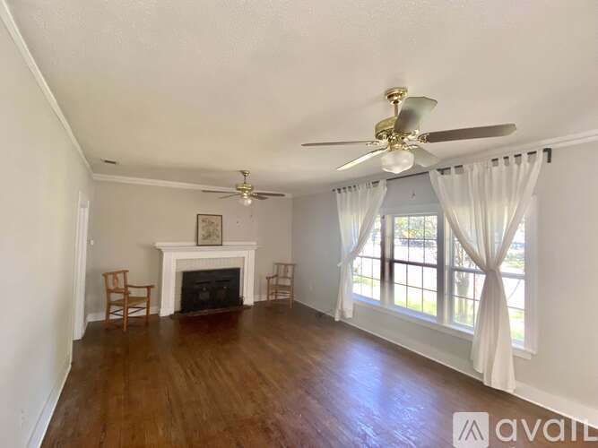 A living room with a fireplace and a ceiling fan.