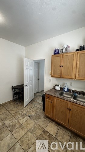 A kitchen with wooden cabinets and a tiled floor.