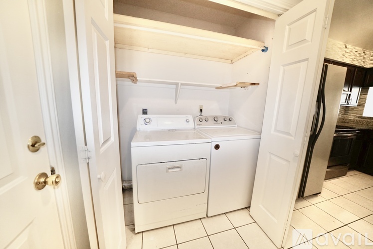 A white washing machine and dryer in a small laundry room.