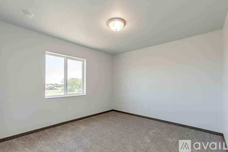 A room with a window and carpeted floor.