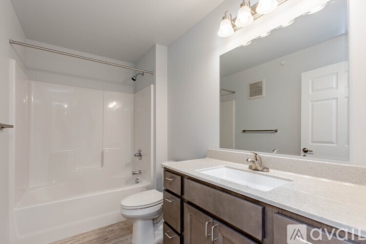A bathroom with a toilet, sink, and mirror.