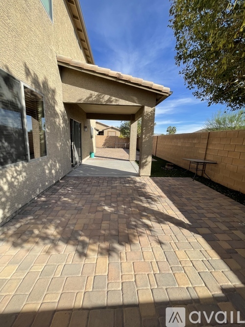 A patio area with a brick patterned floor and a covered walkway.