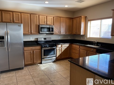 A kitchen with wooden cabinets and a black countertop.