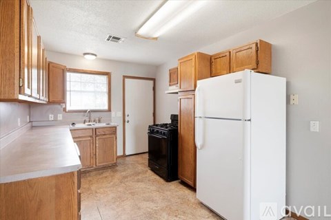 A kitchen with wooden cabinets and a white refrigerator.