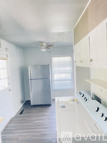 A kitchen with a white stove top oven and a silver refrigerator.