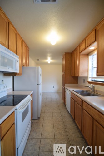 A kitchen with wooden cabinets and white appliances.