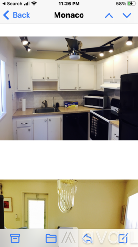 A kitchen with white cabinets and black appliances.