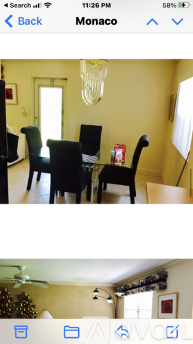 A room with a dining table and chairs.
