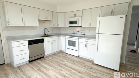 A kitchen with white appliances and cabinets.