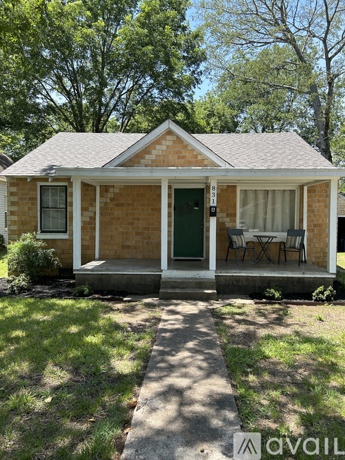 A small house with a green door and a patio table.