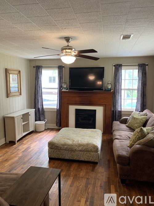 A living room with a fireplace, television, and a couch.