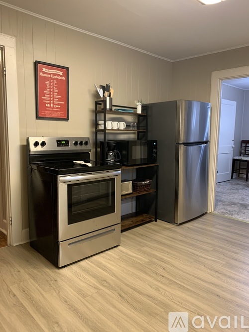 A kitchen with a stove, oven, microwave, and refrigerator.