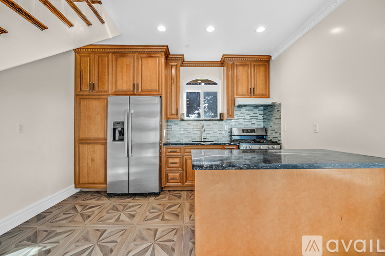 A kitchen with wooden cabinets and a marble countertop.