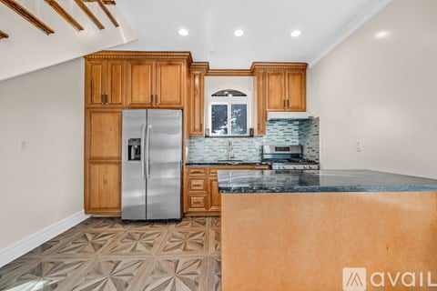 A kitchen with wooden cabinets and a marble countertop.