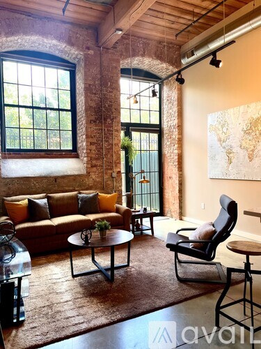 A living room with a couch, chair, and a table.