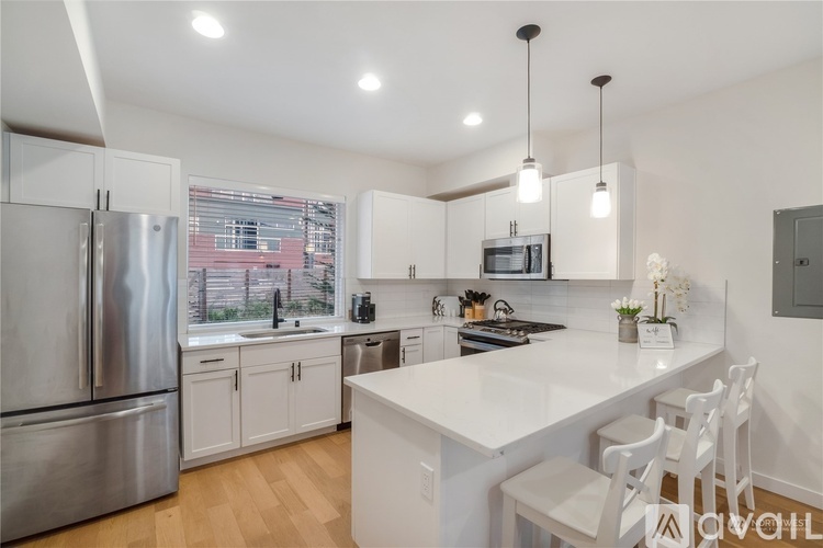 A modern kitchen with white cabinets and a large island.
