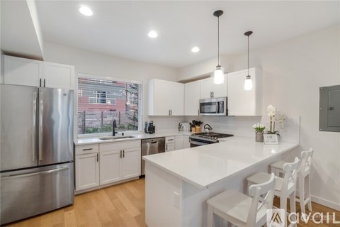 A modern kitchen with white cabinets and a large island.