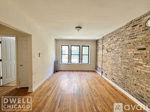 A living room with a fireplace and wooden floors.