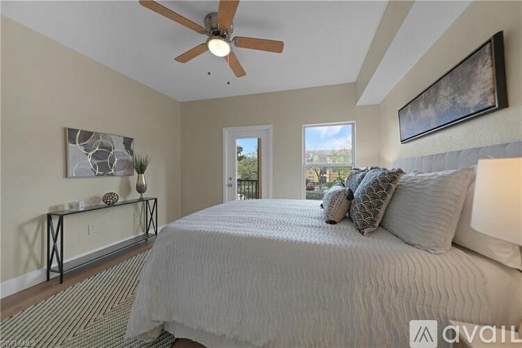 A bedroom with a large bed and a ceiling fan.