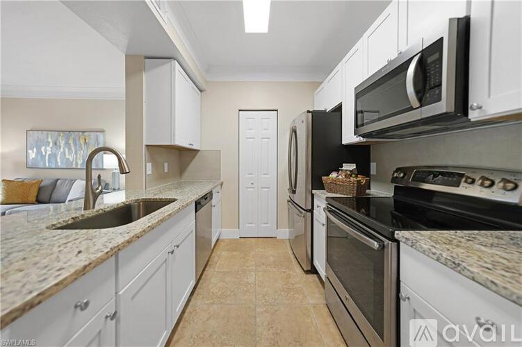 A kitchen with white cabinets and granite countertops.