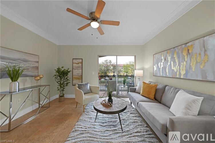 A living room with a grey couch, a coffee table, a ceiling fan, and a painting on the wall.