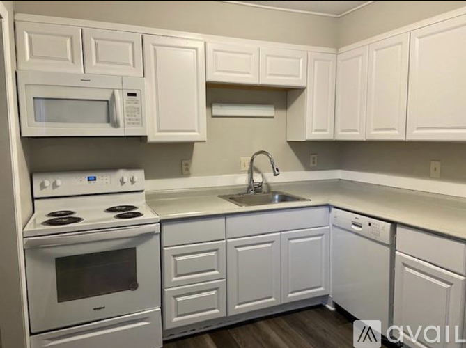 A kitchen with white cabinets and appliances.