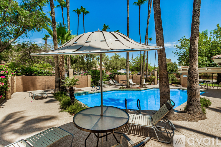 A pool area with a table and chairs under a canopy.