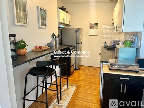A kitchen with a black countertop and a refrigerator.