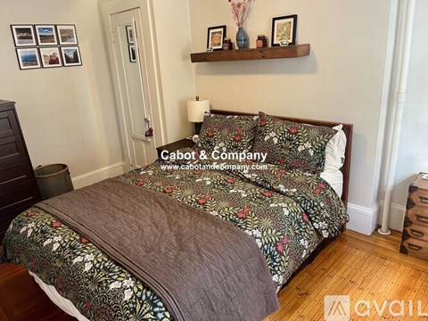 A bedroom with a bed covered in a floral print bedspread.
