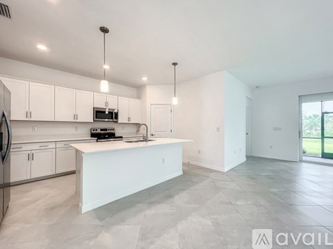 A modern kitchen with white cabinets and a large island.