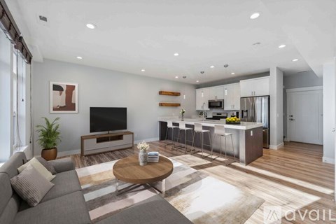 A modern living room with a grey sofa and a wooden coffee table.