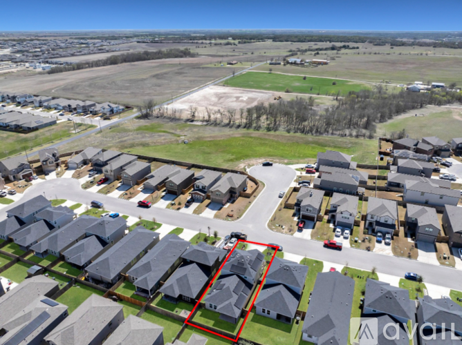 A bird's eye view of a residential area with houses and a red square in the middle.