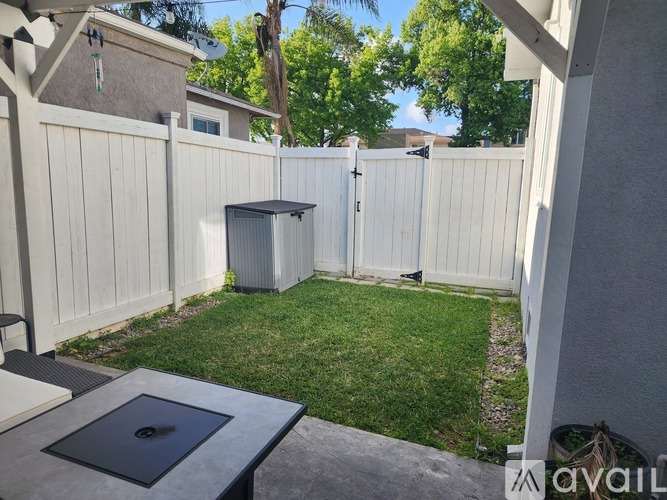 A backyard with a hot tub and a concrete table.