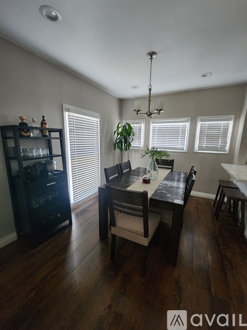 A dining room with a wooden table and chairs.
