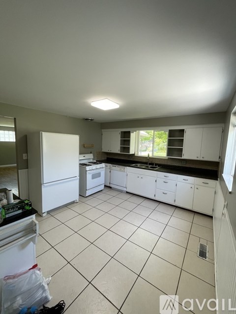 A kitchen with white appliances and cabinets.