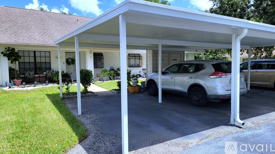 A carport with a white roof and a car parked under it.