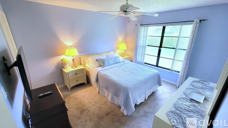 A bedroom with a bed, nightstand, and a television.