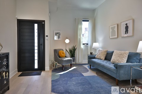 A living room with a blue couch and a black door.